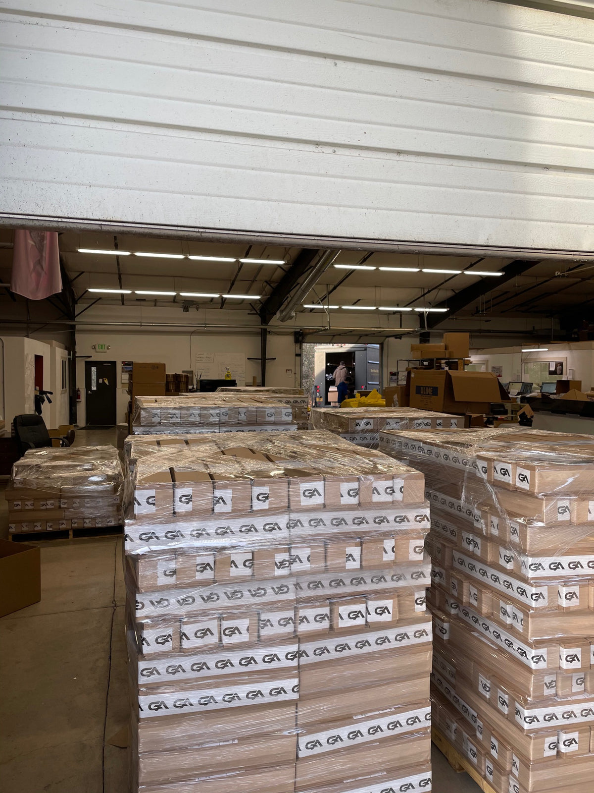 Shrink-wrapped pallets of GutzyAiden mousepads at the warehouse